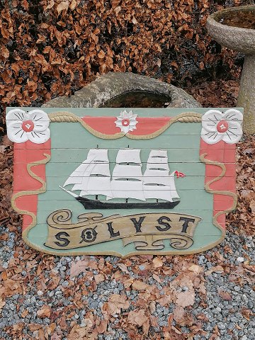 Træskilt dekoreret med sejlskib og "Sølyst"